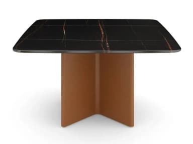 A contemporary square-shaped dining table featuring a black marble top with distinctive gold-copper veining, supported by a sculptural, rectangular pedestal base in a matte tan finish. The tabletop has subtly rounded corners, enhancing its modern aesthetic. — 3D model