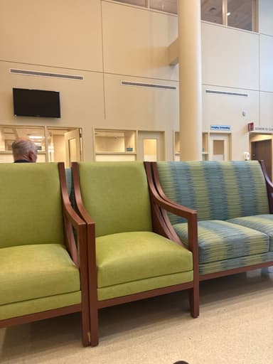 A 3D rendering of a modern armchair featuring a clean, exposed wooden frame and upholstered seat and back cushions. The upholstery is a light green fabric, contrasting with the dark brown wood. The design is simple and geometric, with straight lines for the arms and legs, indicating a contemporary aesthetic. — 3D model