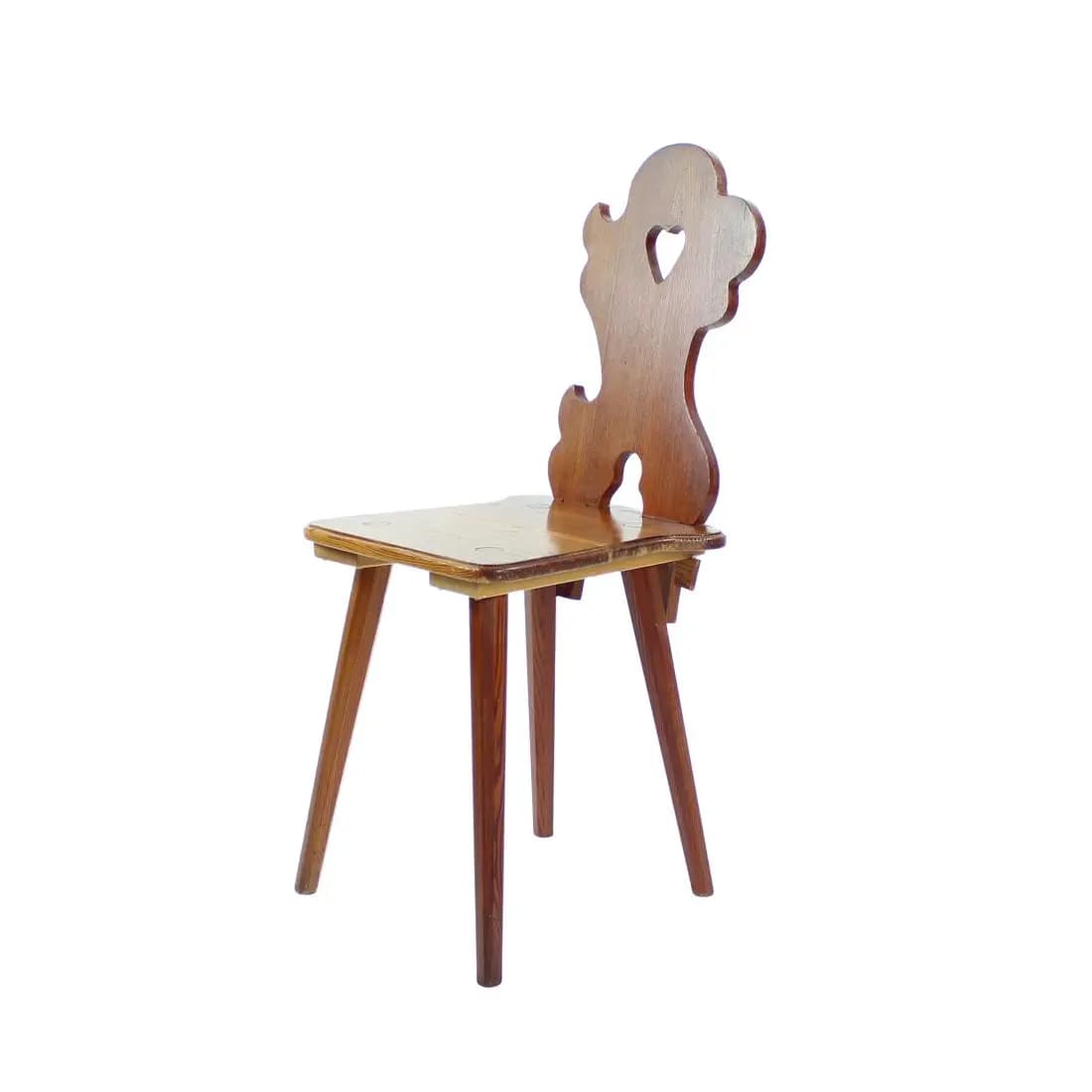 A vintage wooden chair with a uniquely shaped backrest featuring a heart cutout. The chair has a simple, flat seat and four tapered legs. The overall design suggests a rustic or folk art influence. — 3D model