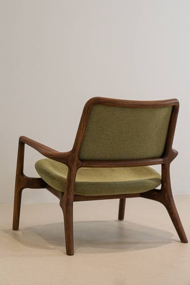 A modern accent chair with a wooden frame and upholstered seat and backrest. The frame has a distinctive curved shape, and the upholstery is a textured green fabric. — 3D model