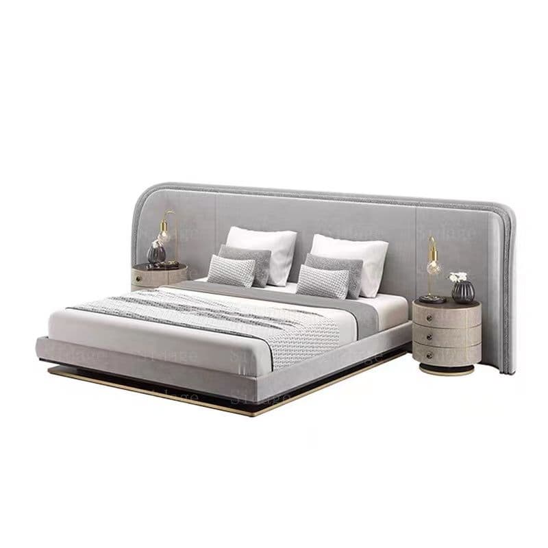 A modern gray upholstered platform bed featuring a wide, curved headboard with seamlessly integrated cylindrical nightstands on either side. The bed includes a mattress, pillows, and a throw blanket. Each nightstand is topped with a table lamp and small decorative items. — 3D model