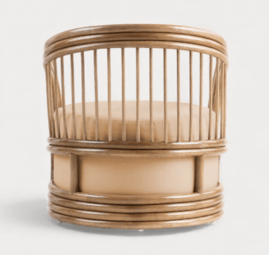 A barrel-shaped armchair constructed primarily from bentwood or cane, featuring a rounded backrest formed by vertical spindles connected to a top and bottom circular frame. The seat and lower body are upholstered in a light tan fabric. The base has subtle feet or glides. — 3D model