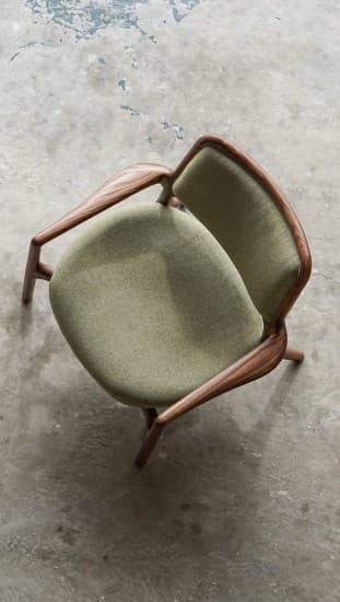 A modern accent chair with a wooden frame and upholstered seat and backrest. The frame has a distinctive curved shape, and the upholstery is a textured green fabric. — 3D model