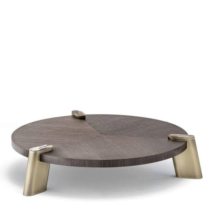 A low-profile round coffee table featuring a dark brown wooden top with a quarter-matched veneer pattern. The table is supported by three wide, sculptural legs made of a brass-finished metal, which rise slightly above the tabletop surface and are accented with small, smooth cap-like elements. — 3D model