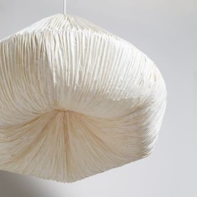 An off-white, cone-shaped pendant light featuring a heavily textured, pleated shade made from a natural fiber material, suspended by a simple white cord from the ceiling. — 3D model