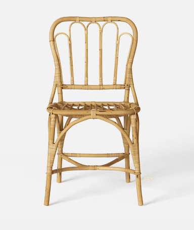 A vintage-style side chair constructed entirely from natural rattan. The chair features a curved backrest with vertical spindles and a woven seat. The legs are joined by a curved stretcher and a lower crossbar for stability. — 3D model