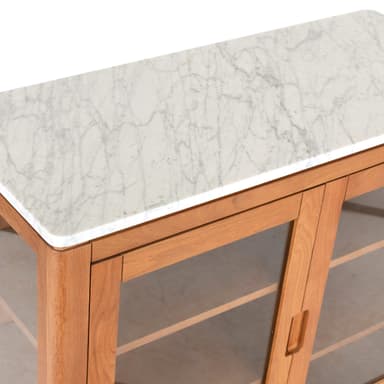 A rectangular display cabinet featuring a white marble top, light-toned wooden construction, and two framed glass doors. The cabinet stands on four tapered legs and includes internal shelving. — 3D model