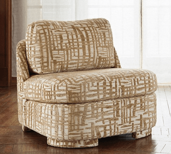 An upholstered slipper accent chair featuring an abstract, geometric pattern in beige and off-white tones. It has a low back, no traditional armrests (a continuous side profile), and a fully upholstered base with integrated, recessed block feet, giving it a modern and compact appearance. — 3D model
