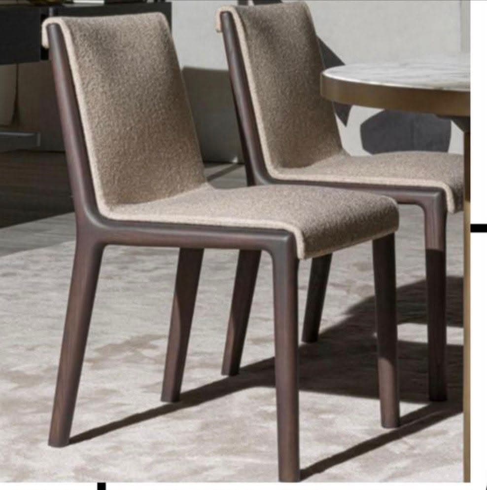A modern dining chair with a wooden frame and upholstered seat and backrest. The frame appears to be made of dark stained wood with a smooth finish. The upholstery is a textured fabric in a neutral, light beige color. The chair has a simple, clean-lined design with four legs that angle slightly outwards. — 3D model