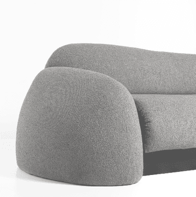 A contemporary sofa with a rounded, organic silhouette. It features a thick, plush seat and backrest upholstered in a textured gray fabric. The armrests are uniquely shaped, widening and curving outwards at the ends, creating a distinctive, sculptural form. The base of the sofa is a solid, dark-colored rectangular block, providing a contrasting foundation to the soft upholstery. — 3D model