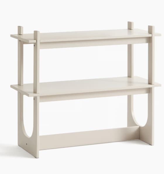 A minimalist two-tier shelving unit with a light beige painted finish, featuring integrated vertical supports and distinctive arched cutouts on the lower side panels. — 3D model