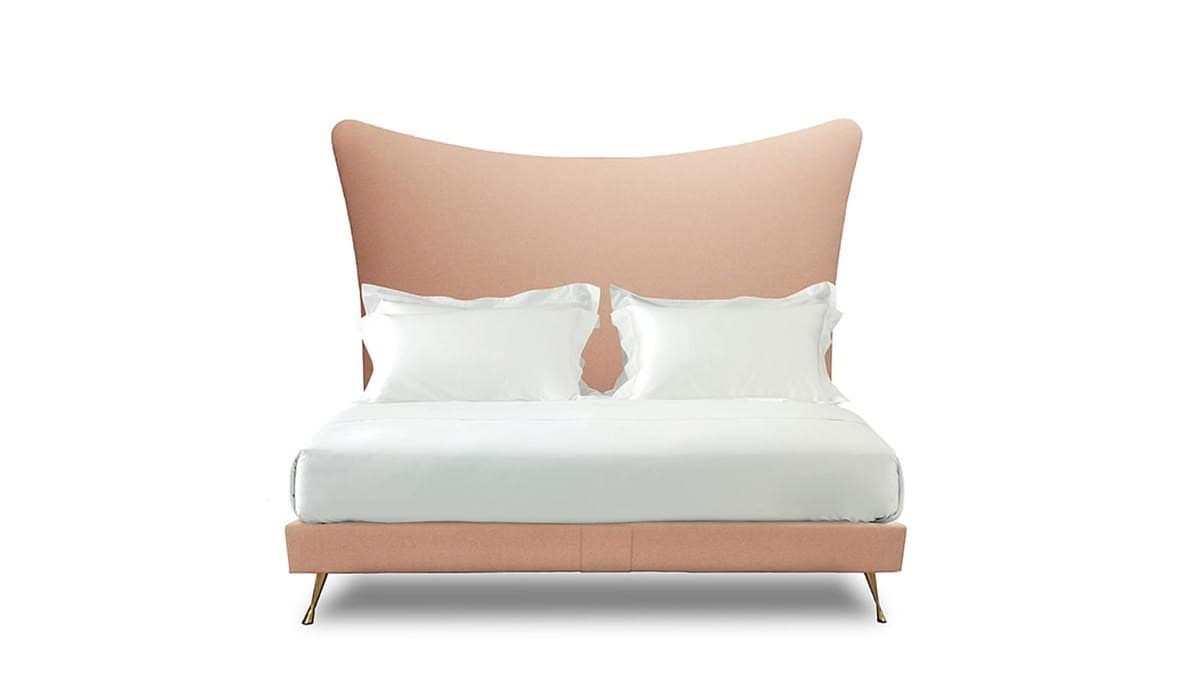 A contemporary bed frame with a high, winged headboard upholstered in a blush-toned fabric. The bed features a platform base supported by slender, angled metal legs. Two white pillows with decorative edging are placed at the head of the bed, with white sheets covering the mattress. — 3D model