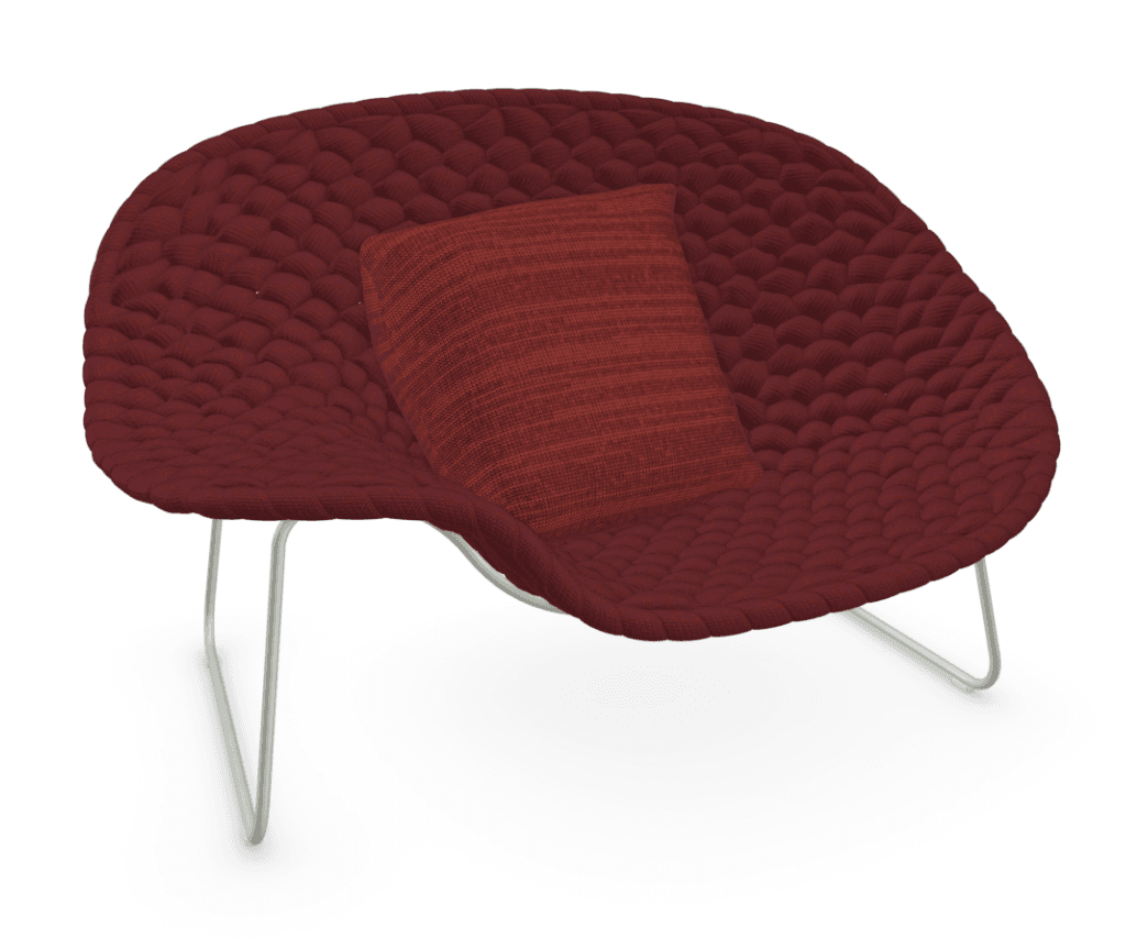 A modern lounge chair featuring a wide, scooped seating surface crafted from a deep maroon knitted or woven cord material, giving it a textured, sculptural appearance. The chair is supported by minimalist, light-colored metal wire frame legs. It includes a rectangular lumbar pillow in a complementary, slightly brighter red fabric. The overall design emphasizes comfort and a contemporary aesthetic. — 3D model