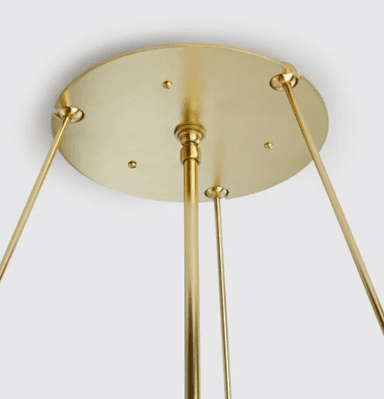 A close-up view of a modern chandelier featuring a circular arrangement of multiple exposed bulbs within a distinctive textured glass shade. The frame and bulb sockets are made of polished brass. The translucent glass shade has an irregular, possibly octagonal or faceted shape, and appears to be made of 'seedy' or artisanal glass, secured by visible brass fasteners around its upper edge. — 3D model