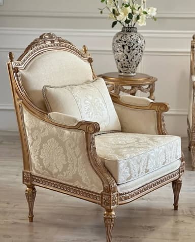 A highly decorative single armchair featuring a gilded, elaborately carved wooden frame and rich, patterned upholstery. The chair includes a separate seat cushion, back cushion, and a decorative throw pillow, all in coordinating fabric. — 3D model