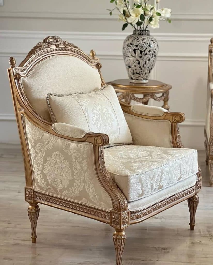 A highly decorative single armchair featuring a gilded, elaborately carved wooden frame and rich, patterned upholstery. The chair includes a separate seat cushion, back cushion, and a decorative throw pillow, all in coordinating fabric. — 3D model