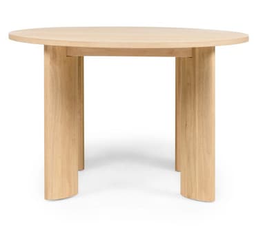 A round dining table crafted from light-toned wood, featuring a circular tabletop supported by four thick, sculptural legs. The legs have a unique curved profile, presenting a minimalist and contemporary aesthetic. The natural wood grain is visible throughout, indicating a solid wood construction or high-quality veneer. — 3D model