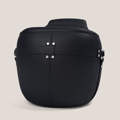 A barrel-shaped upholstered furniture piece, functioning as an ottoman or pouf, covered in black textured material, likely leather or faux leather. It features horizontal strap detailing with silver-toned rivets and D-rings or buckles, adding a decorative and somewhat rugged aesthetic. The top surface appears slightly cushioned. — 3D model