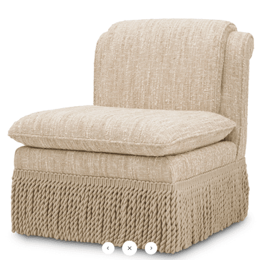 An upholstered armless slipper chair featuring a thick, textured light beige fabric. It has a single, plush seat cushion and a distinctive skirt composed of thick, braided rope-like fringe around the base, concealing the legs. — 3D model