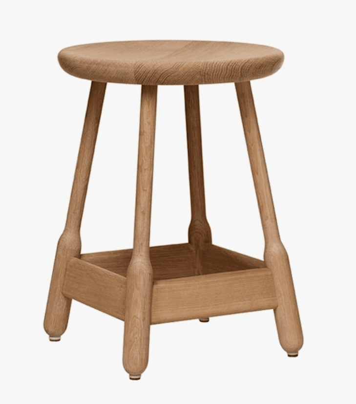 A wooden stool with a rounded seat and four legs. The legs are connected by a square base structure. The stool has a natural wood finish and appears to be made of solid wood. — 3D model