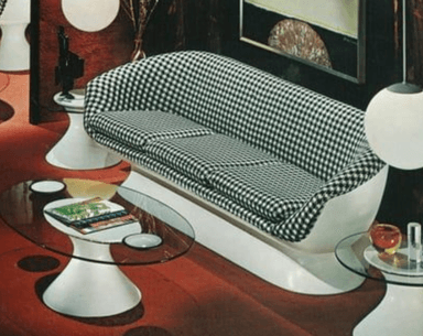 A contemporary two-seater loveseat featuring a striking black and white houndstooth pattern on its upholstery. The seat and backrest are formed from a single, smoothly curved shell, which rests upon a minimalist, solid white pedestal base. Two separate, plush seat cushions provide seating, maintaining the houndstooth motif. The design suggests a mid-century modern influence with a distinct graphic textile choice. — 3D model