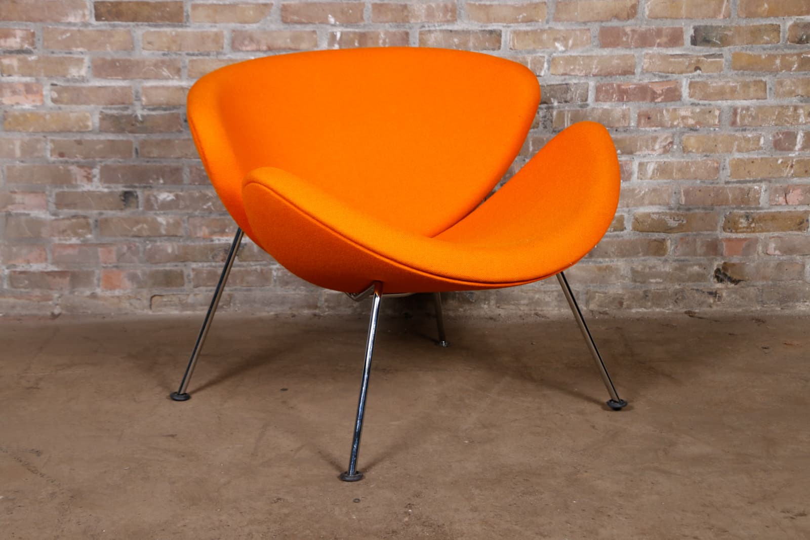 A vibrant orange upholstered lounge chair with an organic, curvilinear design, supported by slender, splayed chrome-finished metal legs. — 3D model