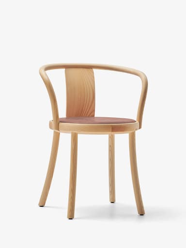 A modern dining armchair featuring a light-toned wooden frame and a padded brown leather seat. The chair's backrest and armrests are formed by a continuous, gracefully curved bentwood piece. It stands on four slender, tapered wooden legs that splay slightly outwards. — 3D model