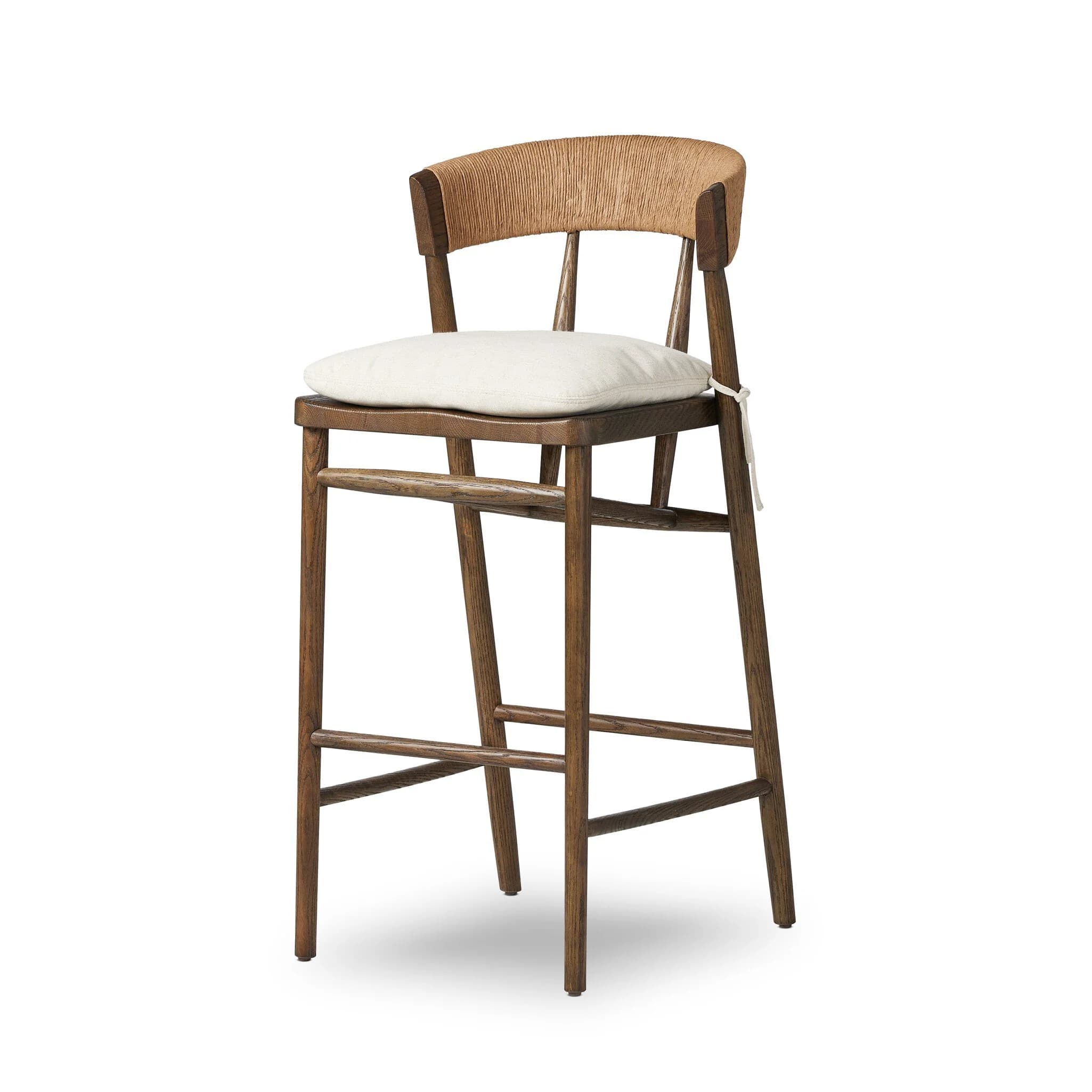 A wooden bar stool with a curved, woven backrest and a cushioned seat. The stool features four legs connected by stretchers for stability. The backrest is made of a natural fiber material, possibly rattan or jute, woven in a vertical pattern. The seat is upholstered with a light-colored fabric cushion, secured by thin ties. The wooden frame has a visible grain pattern, indicating it is likely solid wood. — 3D model