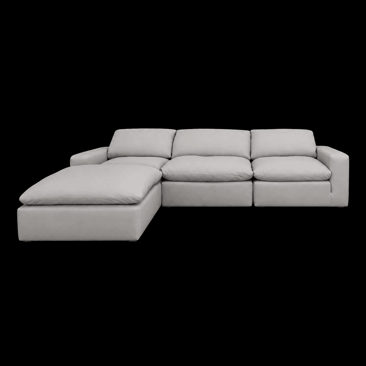 A modular sectional sofa with a chaise lounge extension. The sofa features a low profile, deep seating, and generously padded cushions for the back and seat. The chaise is positioned on the left side when facing the sofa. The upholstery appears to be a light-colored fabric or leather. — 3D model