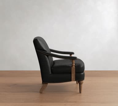 A traditional style armchair upholstered in black leather, featuring prominent brass nailhead trim along the armrests and base. The chair is supported by turned wooden legs and has exposed wooden arm supports, contributing to its classic aesthetic. — 3D model