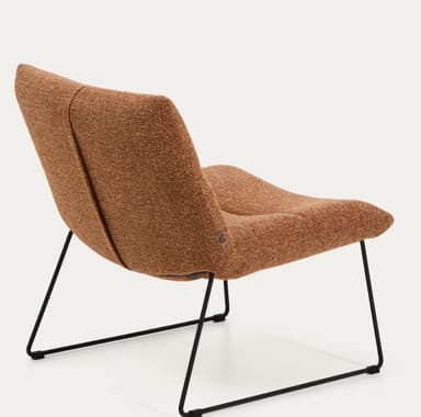 An armless lounge chair featuring a low-slung, ergonomic design. The chair is fully upholstered in a textured, terracotta brown fabric, with segmented cushions forming the backrest and seat. It rests on a minimalist black powder-coated metal sled base, giving it a contemporary aesthetic. The overall profile suggests comfort and relaxation. — 3D model