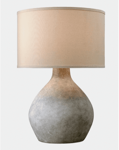 A contemporary table lamp featuring a distinctive gourd-shaped ceramic base with a textured, matte finish that displays a subtle grey-to-brown gradient. The base transitions smoothly into a narrow neck supporting a classic drum-shaped lampshade made of light beige or cream-colored fabric. The overall aesthetic is one of understated organic elegance, suitable for various interior styles. — 3D model
