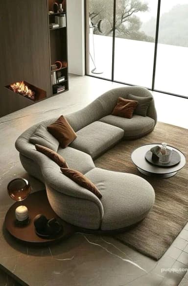 A contemporary, organically shaped sectional lounge sofa upholstered in a light grey textured fabric. The sofa features a continuous, curvilinear form with integrated backrests of varying heights, designed for multiple users. A dark, thin base trim follows the sinuous outline of the piece. Two loose accent pillows, one grey and one brown, are placed on the seating surface. — 3D model