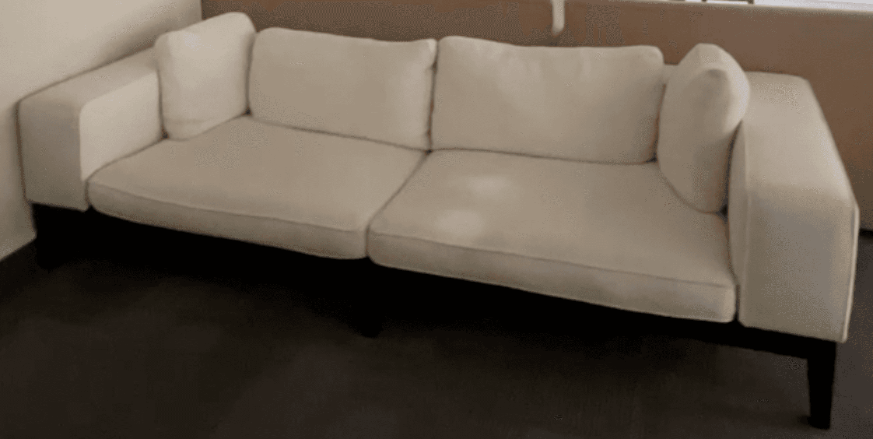 A modern, minimalist sofa featuring white textured fabric upholstery and a distinct exposed black frame. It is designed with two wide square armrests, two large seat cushions, two back cushions, and two smaller accent pillows. The clean lines and contrasting elements give it a contemporary aesthetic. — 3D model