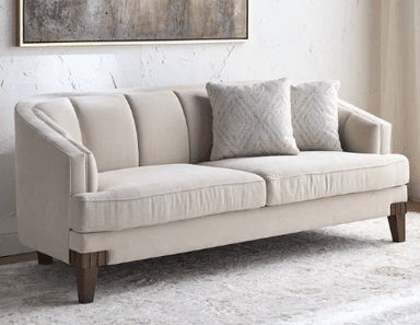 An elegant, cream-colored loveseat featuring an asymmetrical curved back design. The backrest is subtly channel-tufted, providing a structured yet soft appearance. It has two seat cushions and is supported by four dark, tapered wooden legs. Three decorative throw pillows are placed on the seat. — 3D model