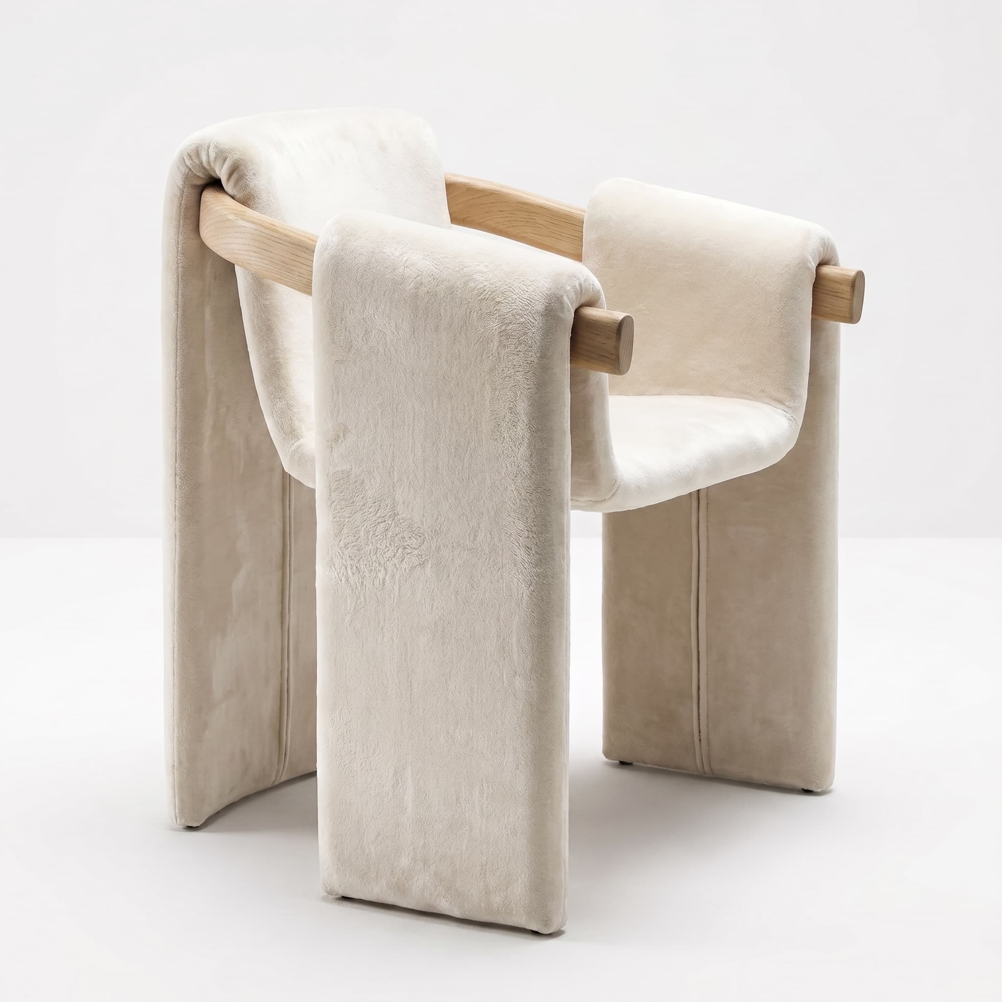 A contemporary armchair featuring a minimalist design with a visible light-toned wooden frame that supports a thick, cream-colored, soft upholstered material. The upholstery is draped over the wooden elements, forming the seat, backrest, and legs of the chair, creating a fluid and sculptural appearance. The fabric has a plush texture, possibly velvet or boucle. The chair stands on the upholstered leg sections, which appear to have small glides or feet for stability. — 3D model