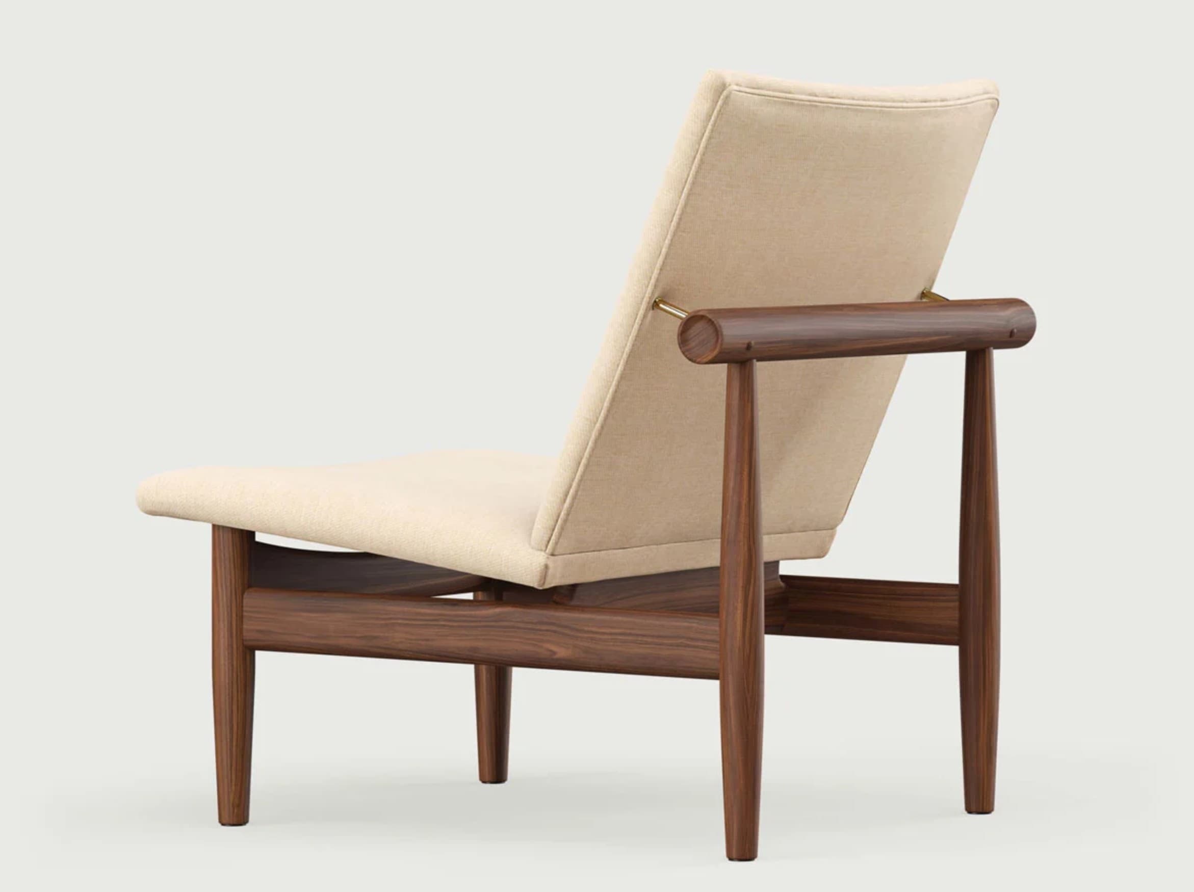 A modern armchair with a minimalist design, featuring a reclined upholstered backrest and seat, supported by a dark wood frame. The armchair has visible wooden armrests with rounded ends, and the frame is constructed from solid wood with a visible grain. The upholstery appears to be fabric in a neutral tone. — 3D model