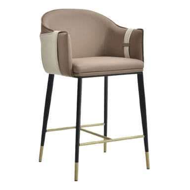 A contemporary bar stool featuring a two-tone upholstered seat and backrest with integrated armrests. The upholstery combines tan and cream tones, accented by a decorative strap on the back. It stands on tapered black metal legs with brass-finished footrests and leg caps. — 3D model