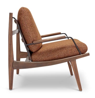 A mid-century modern armchair featuring a wooden frame, upholstered seat and backrest, and leather straps. The armchair has a distinctive silhouette with angled legs and armrests. The backrest is supported by a woven leather panel and held in place by adjustable leather straps with brass buckles. The seat and back cushions are upholstered in a textured, woven fabric. — 3D model