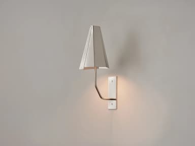A modern wall sconce featuring a rectangular metal backplate, a curved brass arm, and a tapered, multi-faceted metal shade. The shade is light-colored, possibly off-white or champagne, and directed downwards. The backplate appears to be a brushed or matte light-colored metal, secured by two visible screws. The design is minimalist and elegant. — 3D model