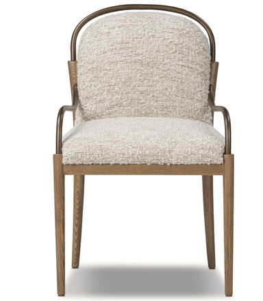An armchair with a upholstered seat and back, featuring a textured cream-colored fabric. The frame consists of wooden legs and a wooden horizontal support, complemented by curved metal armrests with a bronze finish. The design blends natural and metallic elements. — 3D model
