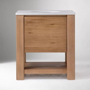 A modern, freestanding bathroom vanity featuring a light-toned oak wood frame and body, topped with a clean white integrated sink and countertop. The design includes a large, full-width drawer and an open lower shelf for additional storage or display. The natural wood grain is prominent, and the overall aesthetic is clean and minimalist. — 3D model