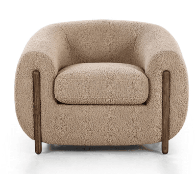 A contemporary, fully upholstered lounge chair with a rounded, organic form, covered in a textured, light beige boucle fabric and supported by short, dark cylindrical wooden legs. — 3D model