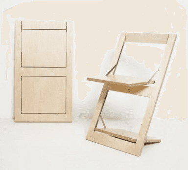 A modern, minimalist folding chair constructed from light-toned plywood, featuring a distinctive Z-shaped frame. The seat and backrest are flat panels, and metal hinges are visible at the pivot points, indicating its collapsible design. The chair has a clean, natural wood finish. — 3D model