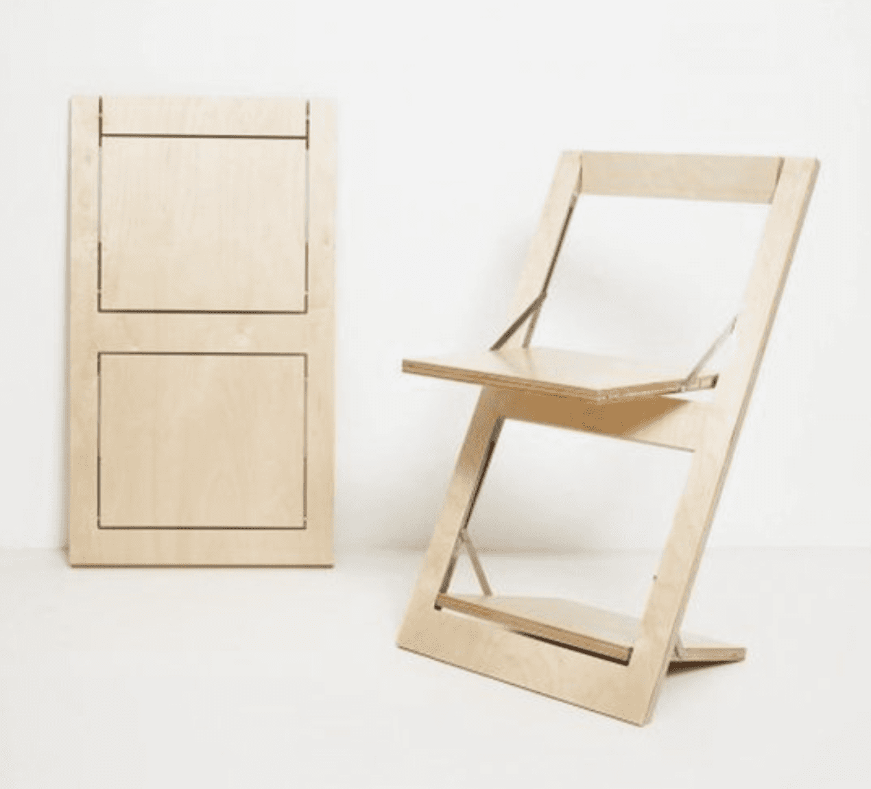 A modern, minimalist folding chair constructed from light-toned plywood, featuring a distinctive Z-shaped frame. The seat and backrest are flat panels, and metal hinges are visible at the pivot points, indicating its collapsible design. The chair has a clean, natural wood finish. — 3D model