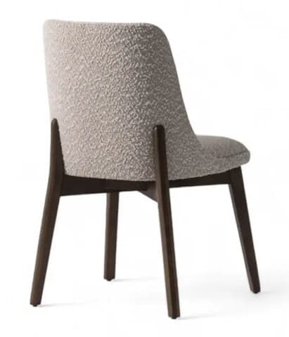 A contemporary armchair with a textured boucle fabric upholstery and dark wooden legs. The chair features a gently curved backrest that extends into the seat, and four tapered legs providing stable support. The overall design is minimalist and elegant. — 3D model