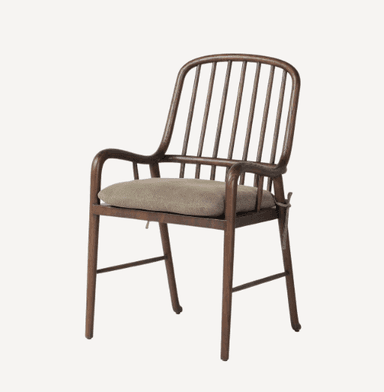 A wooden armchair with a curved backrest composed of vertical spindles. It features rounded armrests and a cushioned seat. The frame is constructed from dark wood, and the cushion is upholstered in a neutral-toned fabric. — 3D model