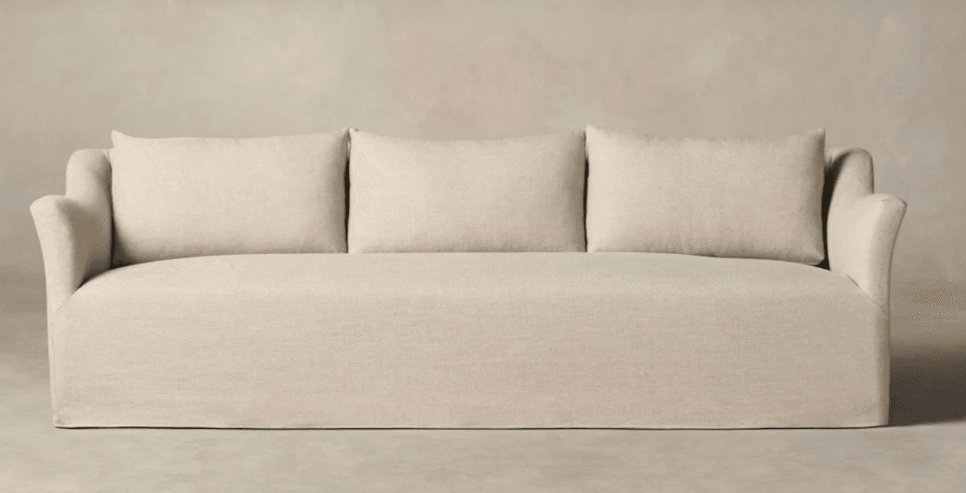 A three-seater sofa with a skirted base and three rectangular back cushions. The sofa features gently sloped arms that curve outward. The upholstery appears to be a textured linen or similar fabric. — 3D model