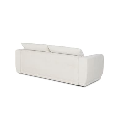A contemporary sofa, upholstered in a light, textured fabric, seen from a rear-side angle. It features a boxy frame with softly rounded armrests and plush, loose back cushions. The base appears recessed with minimal visible feet, contributing to a clean, low-profile aesthetic. — 3D model
