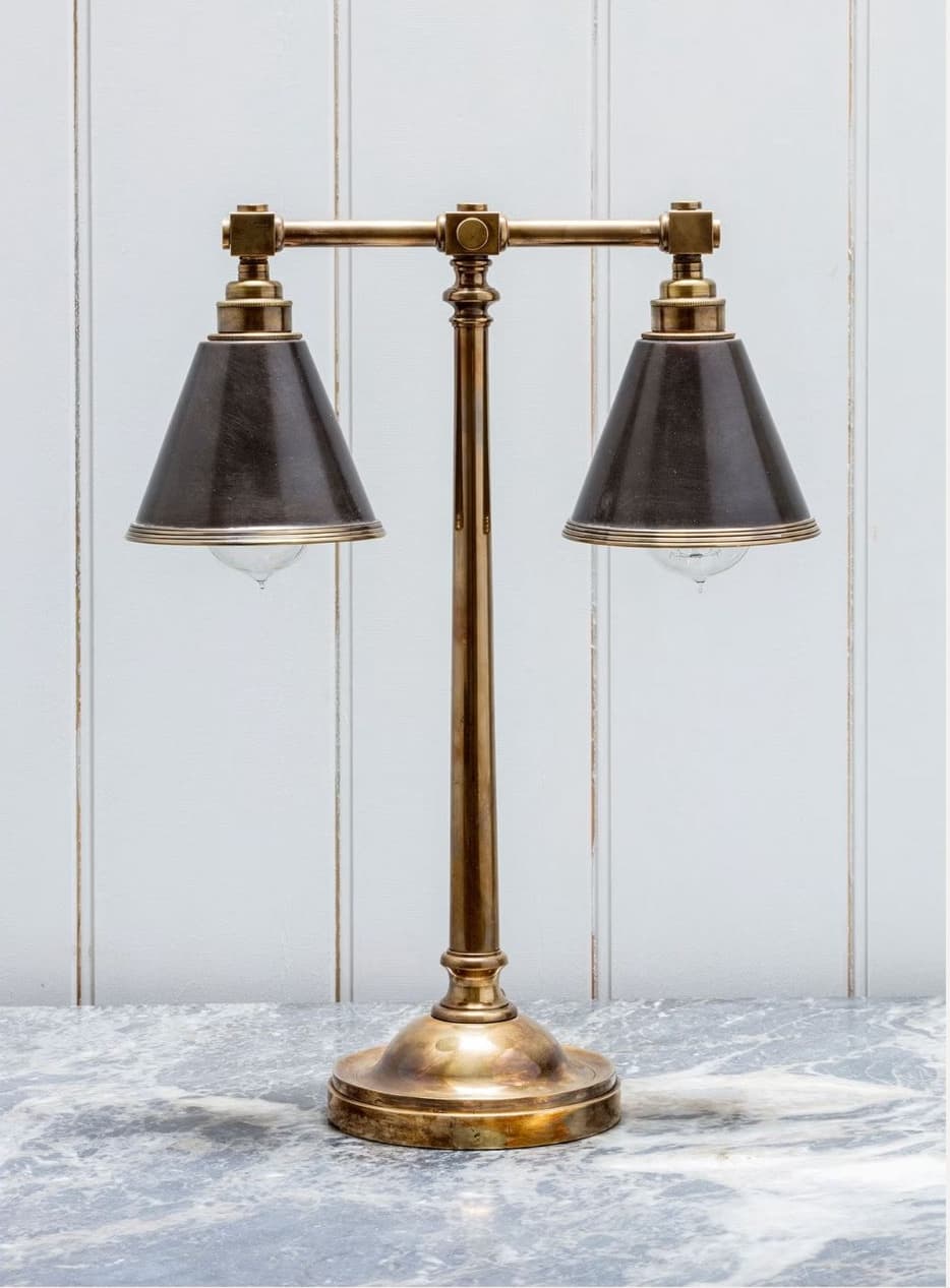 A double-headed table lamp with a brass base and stem, supporting two dark conical lampshades. The arms extending from the central stem to the shades are adjustable. Each shade has a metallic trim. The lamp is designed with a classic aesthetic. — 3D model
